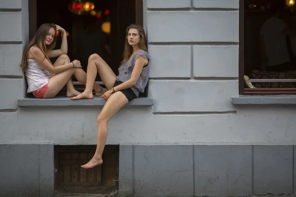 Dívky sedí na okenním parapetu — Stock fotografie