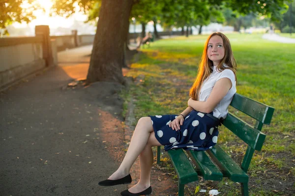 Bonito jovem menina no banco — Fotografia de Stock