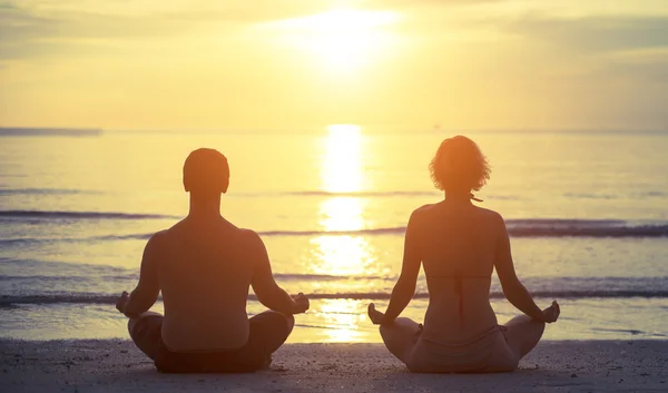 Jeune couple assis dans le yoga Lotus — Photo