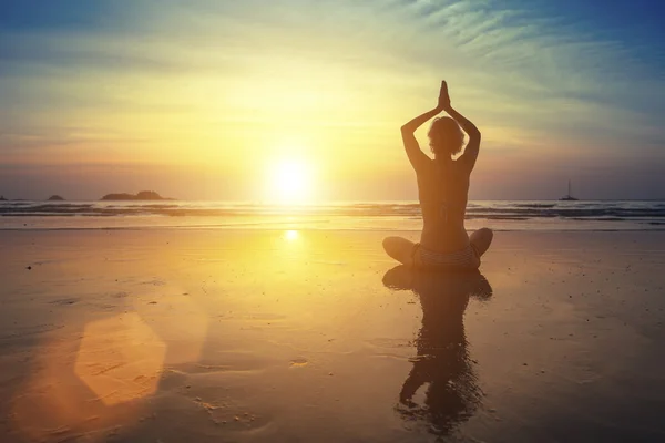 Young woman practicing yoga on beach Royalty Free Stock Images