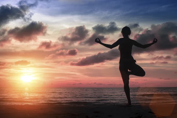 Silhouette Fiatal nő gyakorló jóga — Stock Fotó