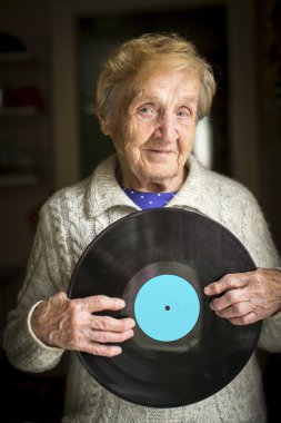 Yaşlı bayan vinil kaydı tutan