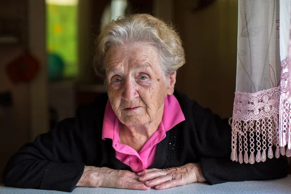 Anciana sentada a la mesa — Foto de Stock