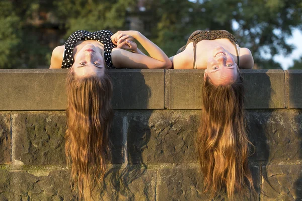 Dos chicas jóvenes mintiendo — Foto de Stock