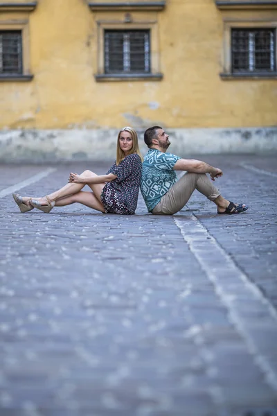 Young couple sitting on the pavement — Stock Photo, Image