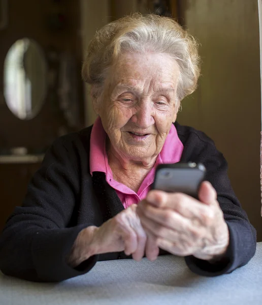 Ältere Frau tippt auf Smartphone — Stockfoto