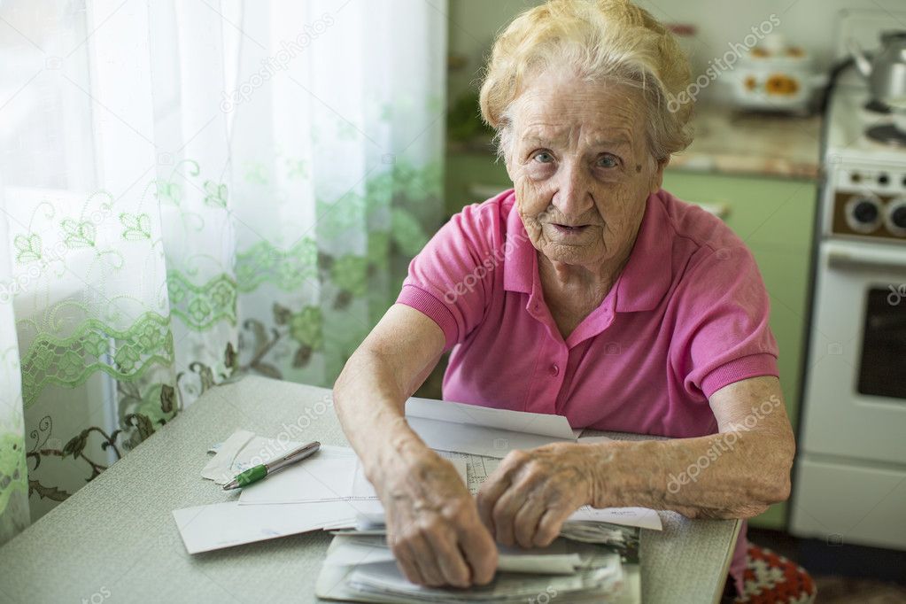 Elderly woman with bills
