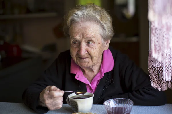 Granny drinking tea — Stockfoto