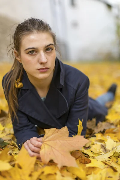 Chica acostada en hojas caídas . — Foto de Stock