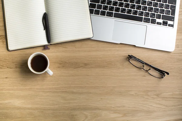 Bloc de notas con bolígrafo, taza de café, vasos y portátil — Foto de Stock