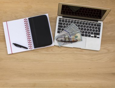 Laptop, defter ve kalem, iş kart sahibi ve para.
