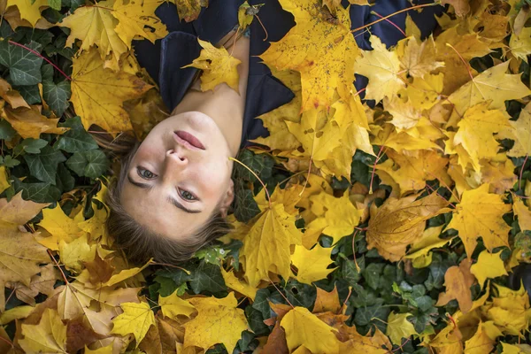 Chica acostada en hojas caídas —  Fotos de Stock