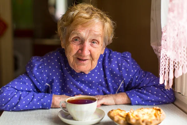 Frau trinkt Tee mit Brötchen — Stockfoto