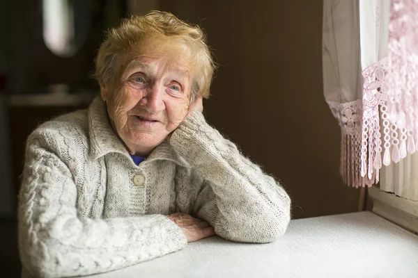 Vrouw zitten dromerig door het venster — Stockfoto