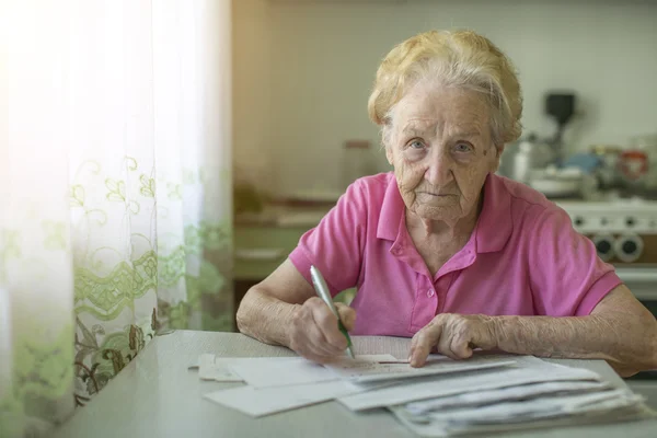 Seniorin füllt Quittung aus — Stockfoto