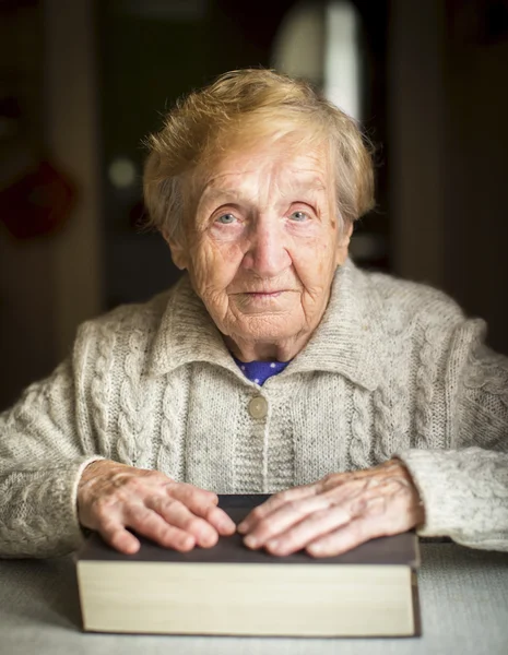 Femme âgée assise à la table — Photo