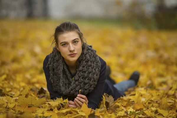 Jolie fille allongée sur des feuilles — Photo