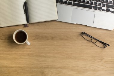 Kalem ve ahşap masa üstünde laptop ile not etmek