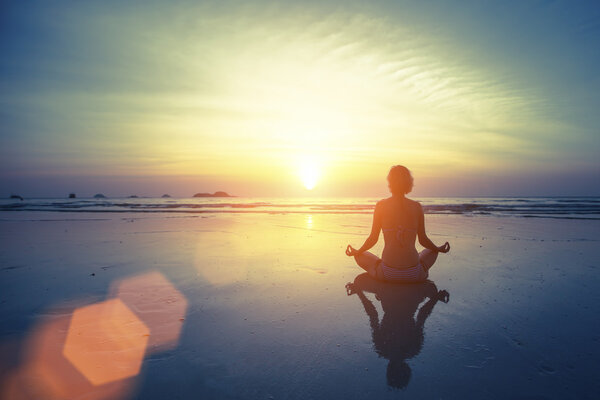 Meditating girl on sea background