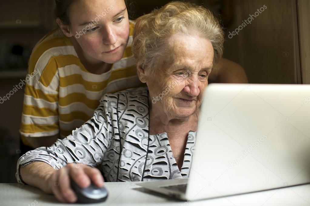 Mature woman wiith granddaughter work on the computer.