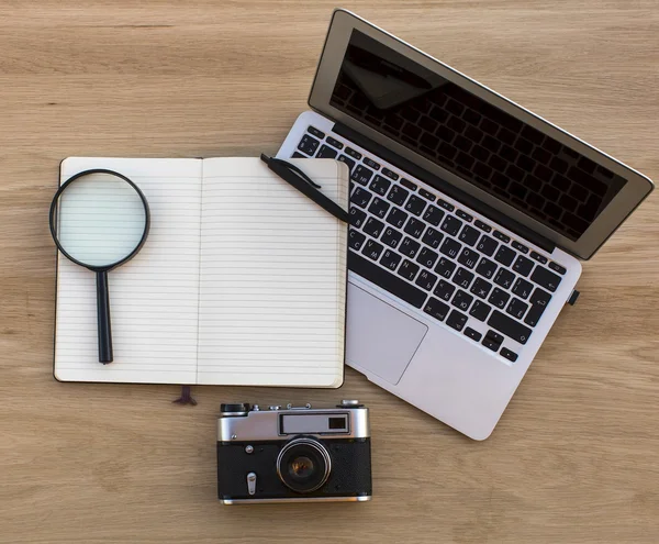 Laptop, Notepad, Magnifier and film camera — Stock Photo, Image