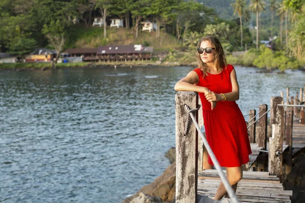 Jeune femme en robe rouge et lunettes de soleil — Photo