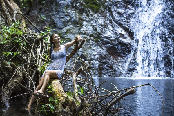 Femme assise près de la cascade — Photo