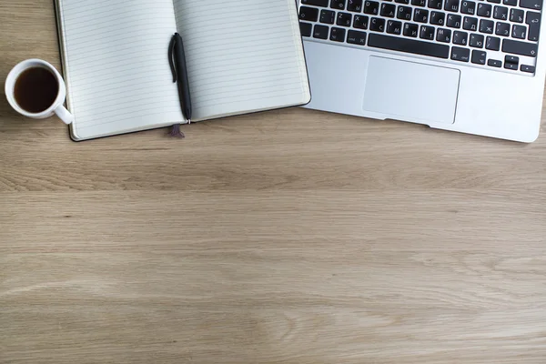Ноутбук, блокнот и чашка кофе на столе — стоковое фото