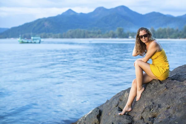 Kobieta w żółtej sukience na klifie — Zdjęcie stockowe