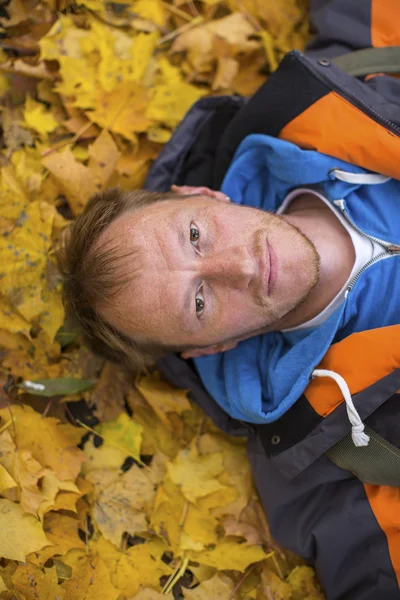 Homme couché sur les feuilles d'automne — Photo