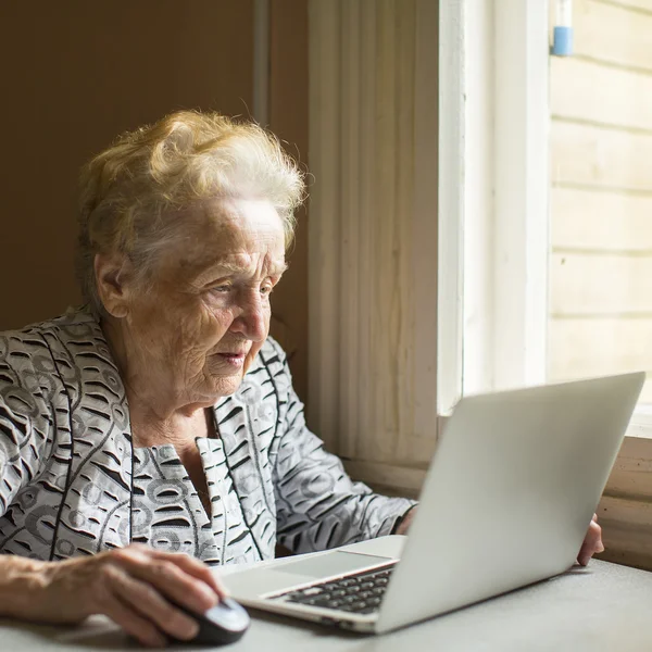 Anciana mujer con ordenador portátil — Foto de Stock