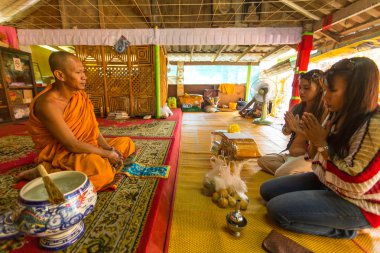 women give offerings to monk in monastery