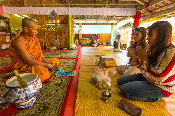 Women give offerings to monk in monastery — ストック写真