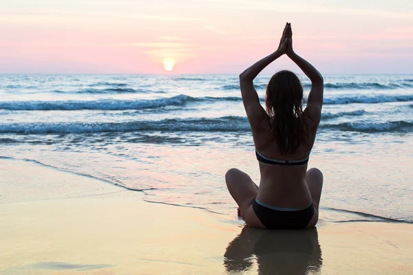 Kadın plajda yoga yapıyor. — Stok fotoğraf