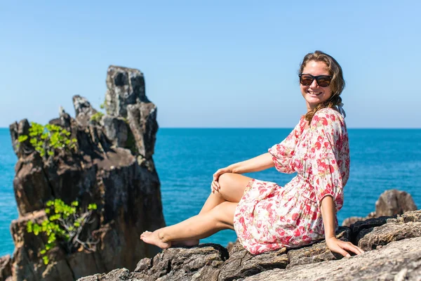 Mulher sentada em rochas perto do mar — Fotografia de Stock