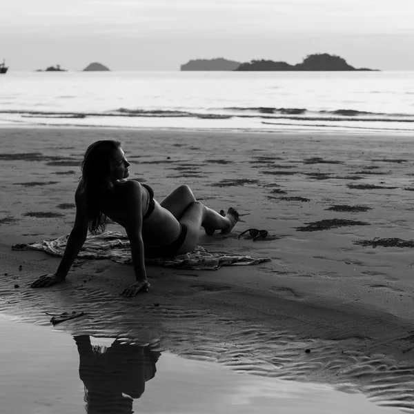 Mooie vrouw liggend op het strand — Stockfoto