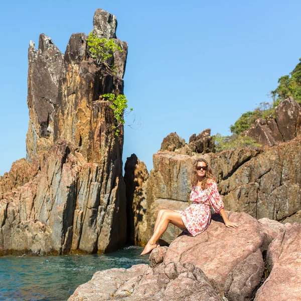 Meisje op een kust rotsen — Stockfoto