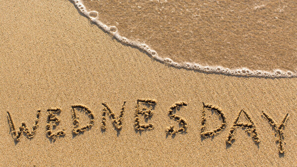 Inscription WEDNESDAY on sand
