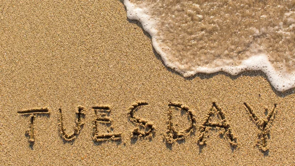 Inscription TUESDAY on sand — Stock Photo, Image