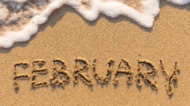 Inscription FEBRUARY on sand