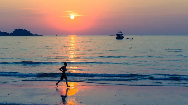 Silhouette dell'uomo che corre sulla linea costiera — Foto Stock