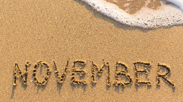 Inscription NOVEMBER on sand — Stock Photo, Image