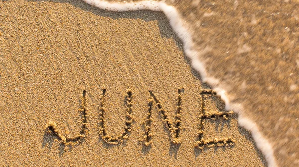 Inscription JUNE on sand — Stock fotografie