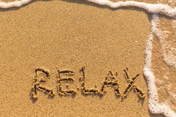 Relaxe - palavra desenhada na praia de areia — Fotografia de Stock