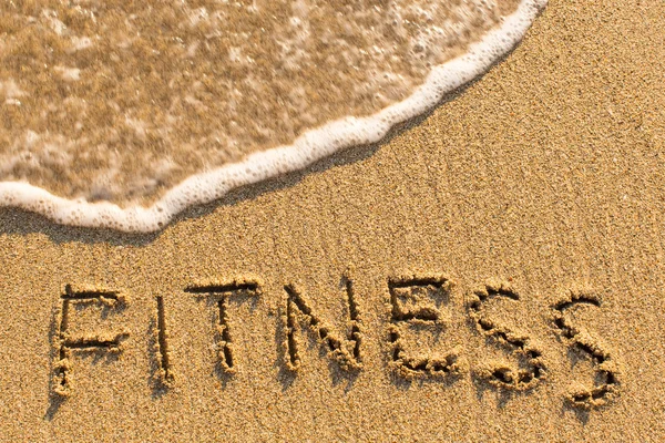 Fitness - parola disegnata sulla spiaggia di sabbia — Foto Stock