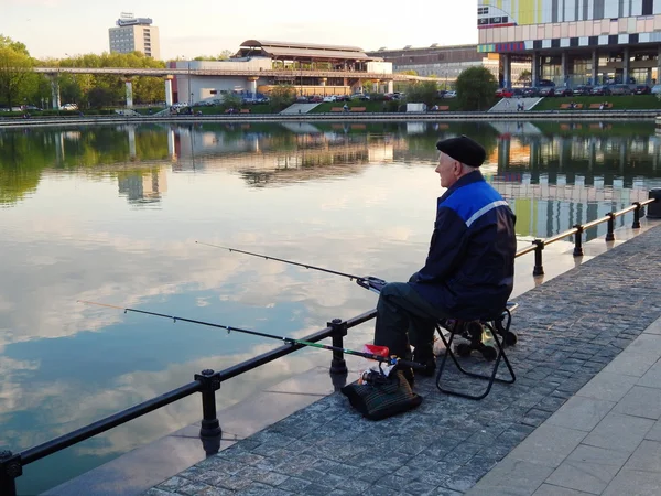 Un anciano está pescando en el estanque de Ostankino en Moscú. mayo, 2016 . Fotos de stock libres de derechos