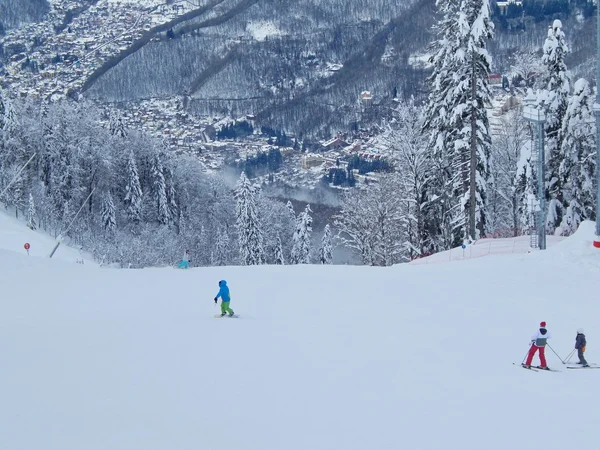 Estância de esqui "Gornaya karusel" ("Carrossel de montanha"), 1500 metros, Krasnaya Polyana, Sochi, Rússia. Janeiro de 2015. Rosa Khutor no fundo da montanha . — Fotografia de Stock