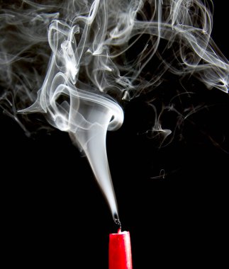Sönmüş bir mumdan bir tutam duman yükselir.