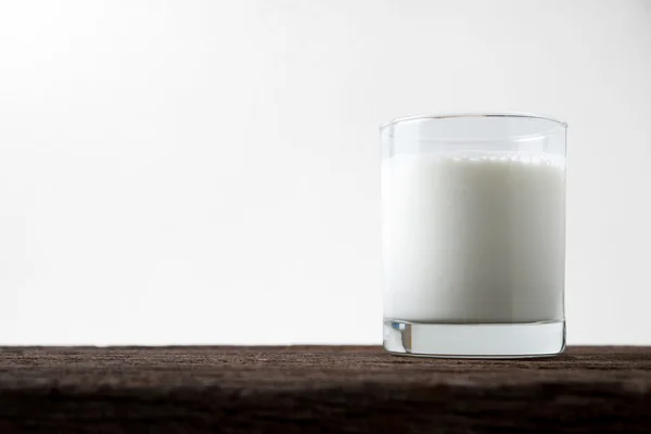 Milk glass on old wood table — Stock Photo, Image