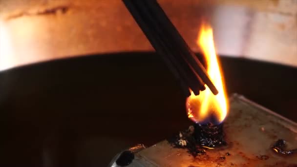 Incense sticks burn up at candle — Stock Video